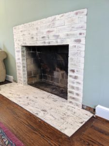 Brick fireplace painted with Romabio Paints Classico Limewash in the color Riposo Beige