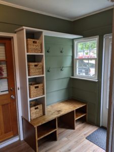 Finished build of bench with storage, shelving, and hooks